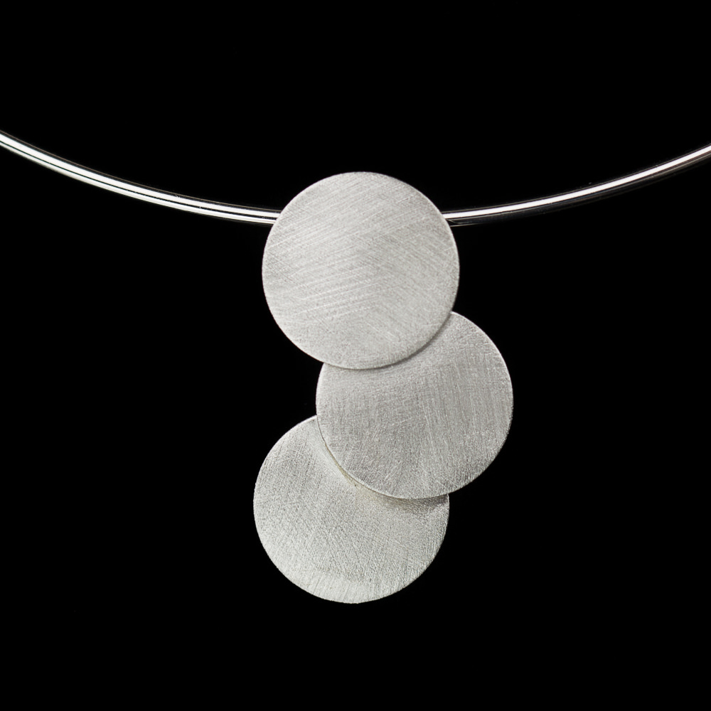 Stijve zilveren ketting met hanger van matte cirkels