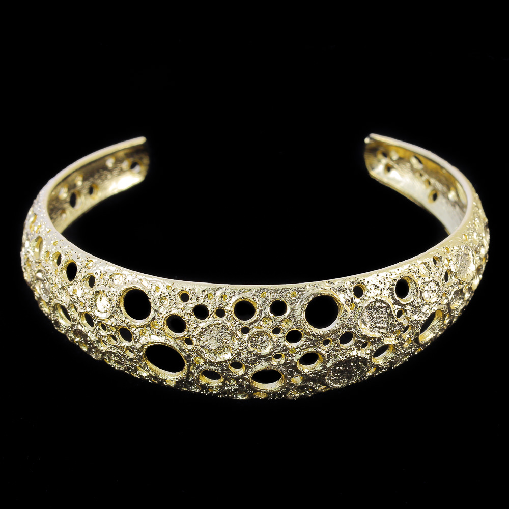 Smalle en vergulde armband met bewerkte schitteringen